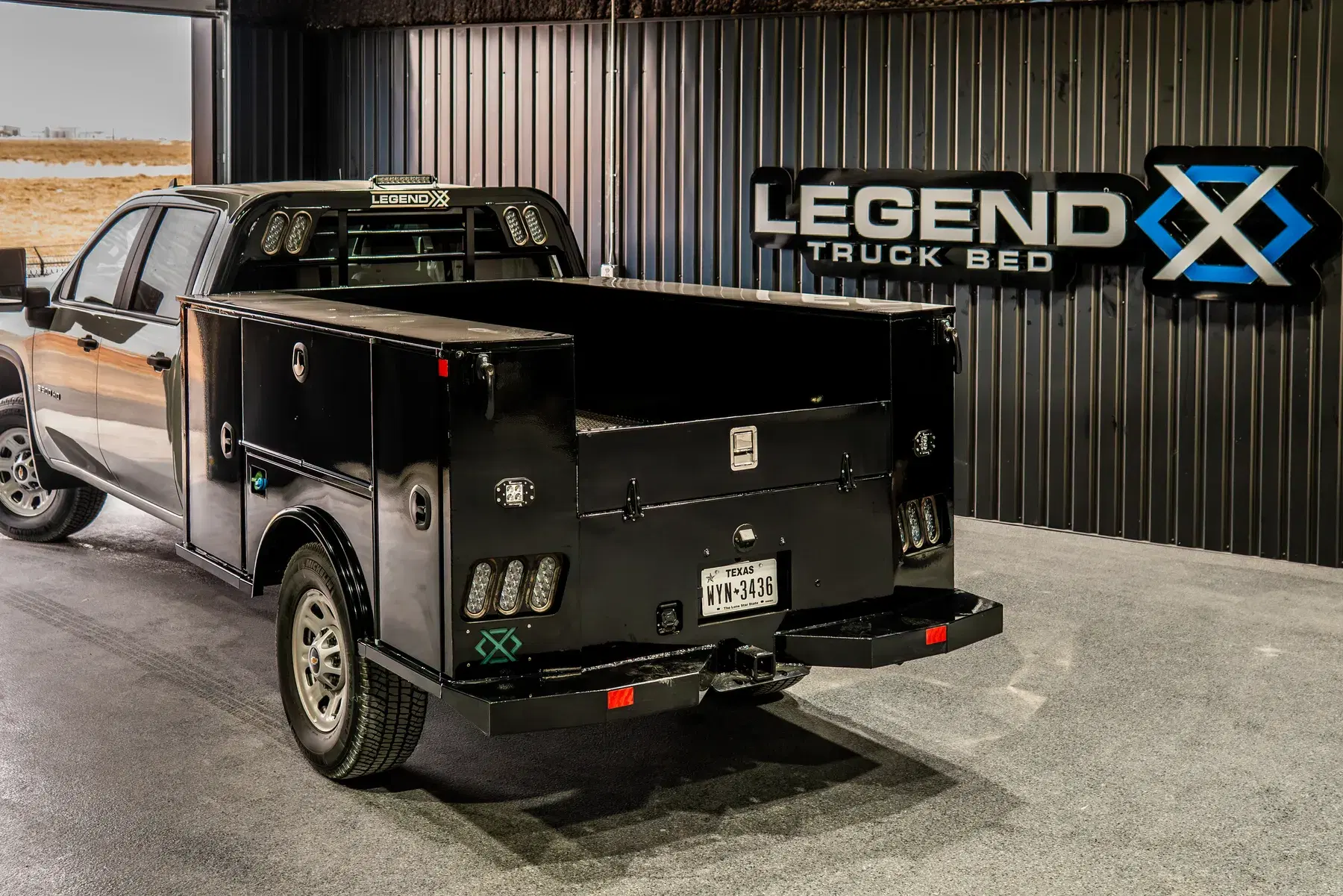 Titan service body in the Legend X showroom beside the illuminated Legend X Truck Beds sign