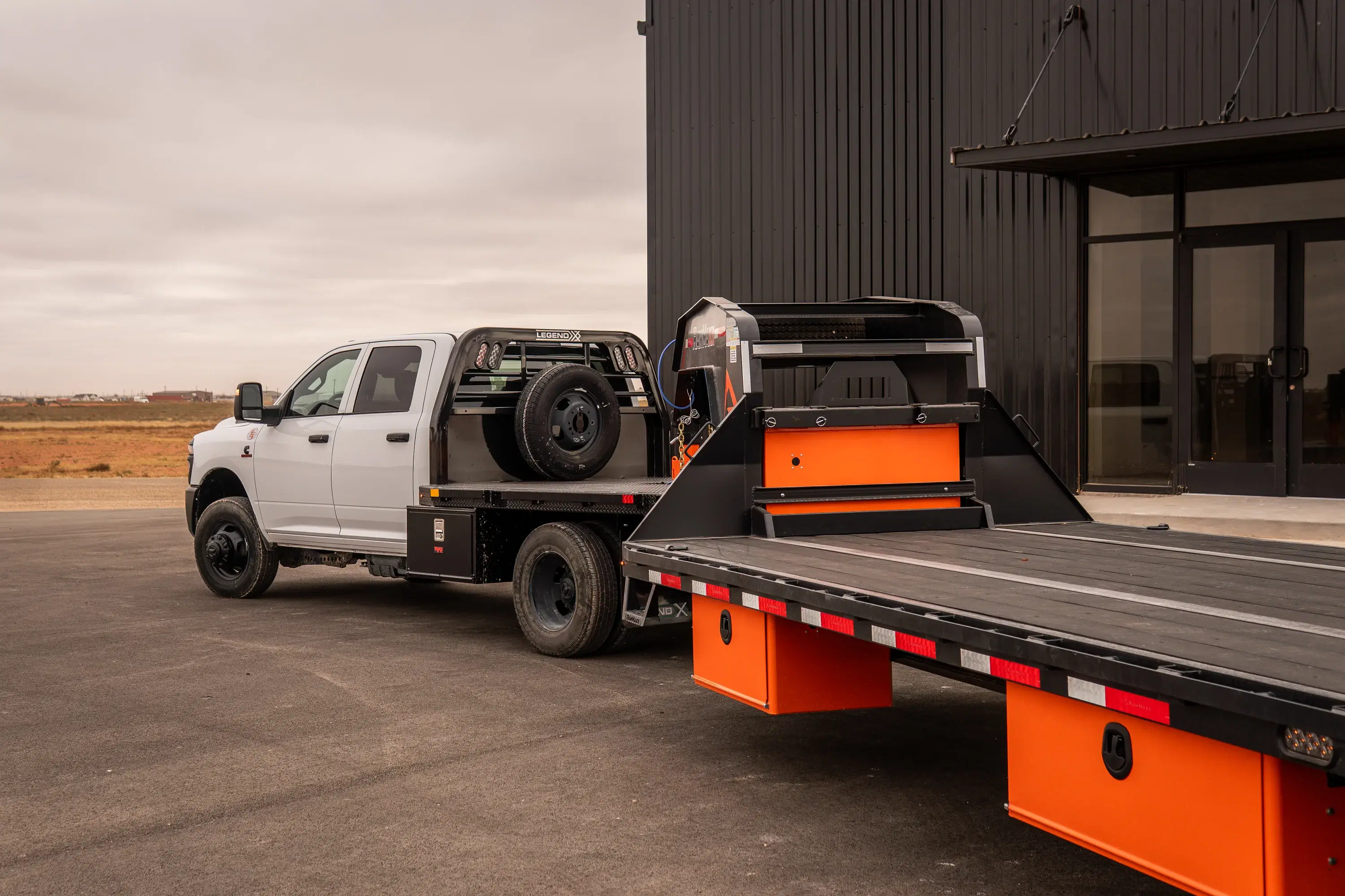 Ram 3500 with a Legend X flatbed hitched to a gooseneck trailer