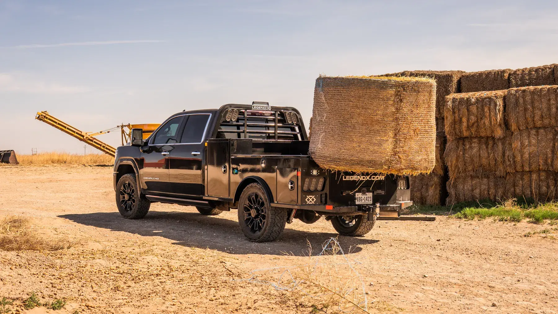 Apollo bed with bale spikes carrying a round hay bale on a West Texas ranch